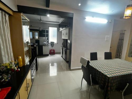 a kitchen and a dining room with a table and chairs at SSV Home stay in Tirupati