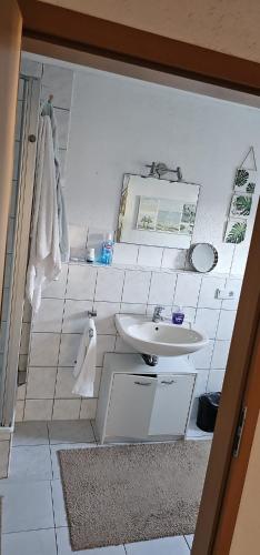 a white bathroom with a sink and a mirror at Charmante Ferienwohnung in Zell an der Mosel