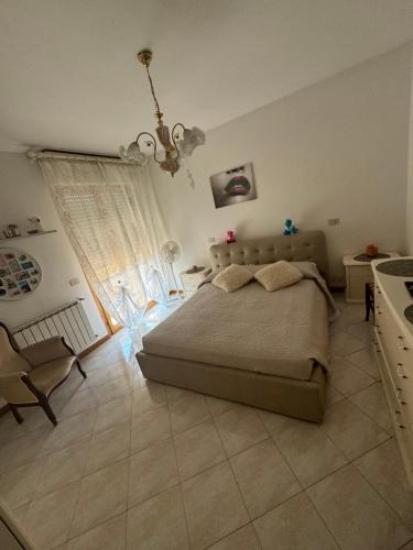 ein Schlafzimmer mit einem Bett und einem Kronleuchter in der Unterkunft La casa di Mihaela in Cinquale