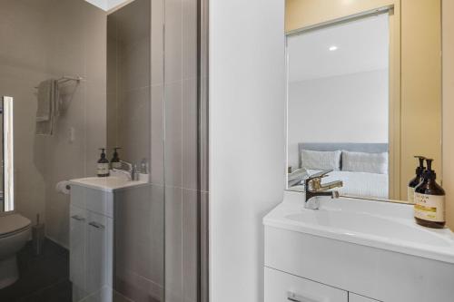 a bathroom with a shower and a sink and a mirror at City Centre Class in Christchurch