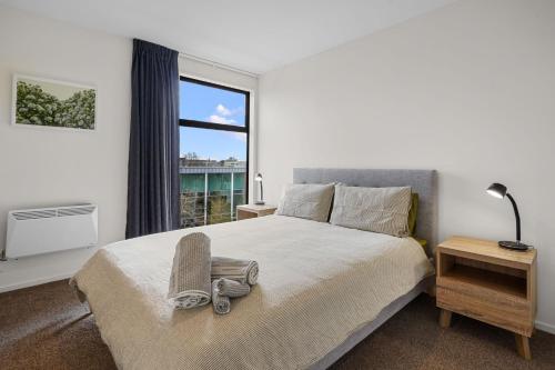 a bedroom with a bed and a large window at City Centre Class in Christchurch