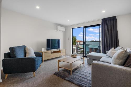 a living room with two couches and a tv at City Centre Class in Christchurch