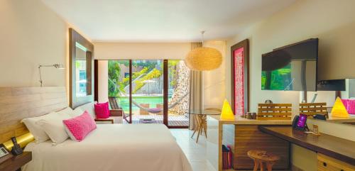 a bedroom with a large bed and a desk with a desk at Hotel Xcaret Mexico All Parks All Fun Inclusive in Playa del Carmen