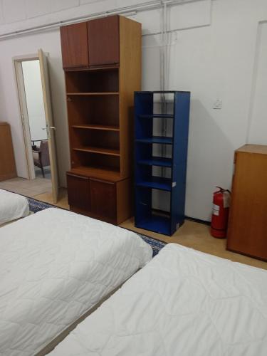 una camera con due letti, un comò e scaffali di City Central a Paraćin