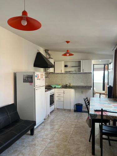 a kitchen and dining room with a table and a refrigerator at Alojamiento ruta 3 in Trelew