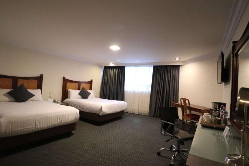 a hotel room with two beds and a window at Best Western Plus Gran Marques in Toluca