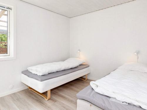 two beds in a white room with a window at 4 star holiday home in Gedsted-By Traum in Gedsted