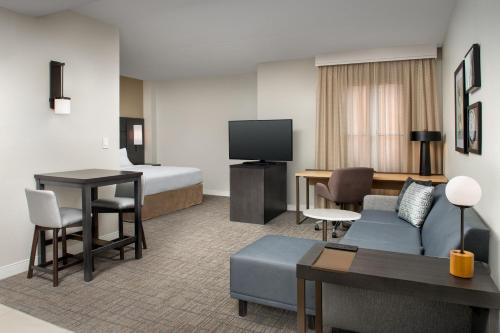 a hotel room with a bed and a living room at Residence Inn by Marriott Phoenix Airport in Phoenix
