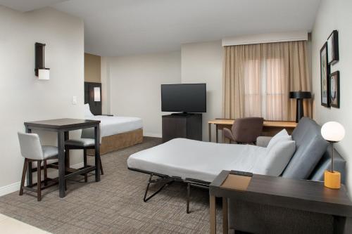 a hotel room with a bed and a desk at Residence Inn by Marriott Phoenix Airport in Phoenix