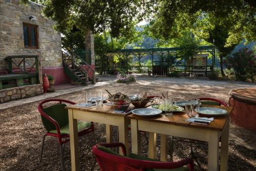 a wooden table with chairs and a table with food on it at Akros Oreon Houses in Káto Sími