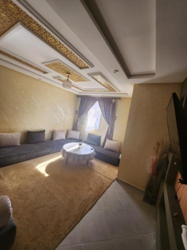 a living room with a couch and a table at Agadir anza résidence miftah sahil in Agadir
