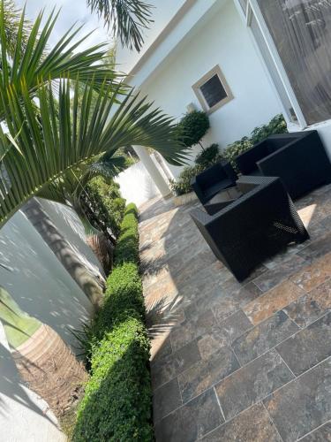 a patio with chairs and a palm tree at Bienvenido a su casa in Concepción de La Vega