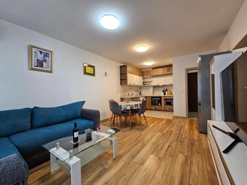 a living room with a blue couch and a table at Brand new apartment with free parking near city center in Sofia