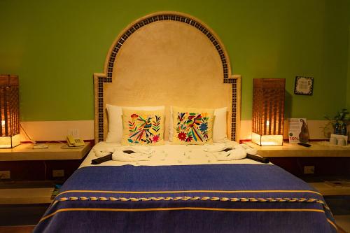 a bedroom with a large bed in a green wall at Hotel Boutique Casa San Angel in Mérida