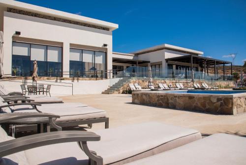 a resort with a pool and chairs and a building at Voyage Vacation Club in Rosarito