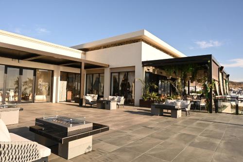 a building with a patio with couches and tables at Voyage Vacation Club in Rosarito