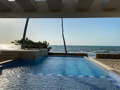 a swimming pool with a view of the ocean at Cabañas Privadas en Playas del Francés con Piscina in San Silvestre
