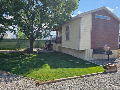 a small house with a tree in a yard at JW Grand Junction in Grand Junction