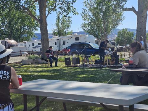 a group of people sitting around a picnic table in a park at JW Grand Junction in Grand Junction