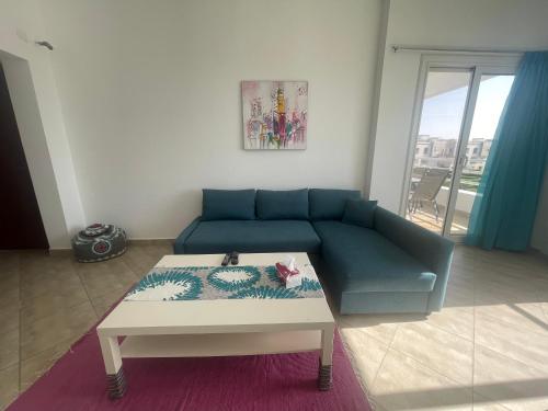 a living room with a blue couch and a coffee table at شاليه in El Alamein
