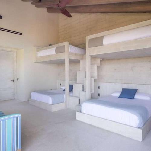 a bedroom with two bunk beds and a ceiling at Beachfront house in Kupuri Punta Mita in Puerto Vallarta