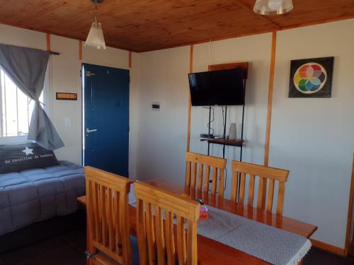 a living room with a table and chairs and a couch at Portal del Sol in Villa Yacanto