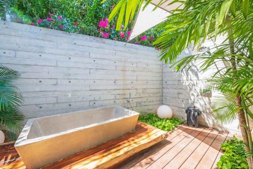 a bath tub sitting on a wooden deck with plants at Beachfront house in Kupuri Punta Mita in Puerto Vallarta