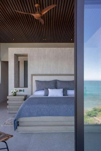 a bedroom with a bed and a ceiling fan at Beachfront house in Kupuri Punta Mita in Puerto Vallarta