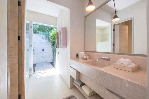 a bathroom with a sink and a mirror at Beachfront house in Kupuri Punta Mita in Puerto Vallarta
