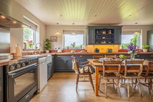 a kitchen with blue cabinets and a table with chairs at Cutbush Farm House in Hingham