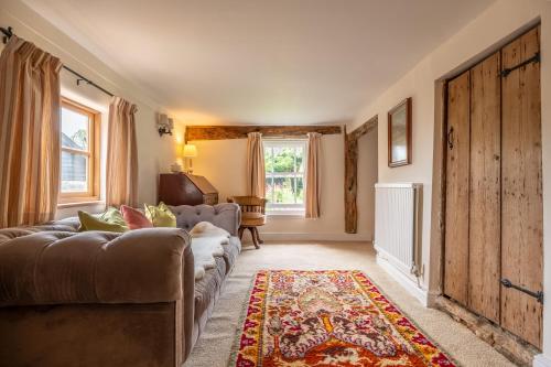 a living room with a couch and a rug at Cutbush Farm House in Hingham