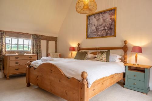 a bedroom with a large wooden bed in a room at Cutbush Farm House in Hingham