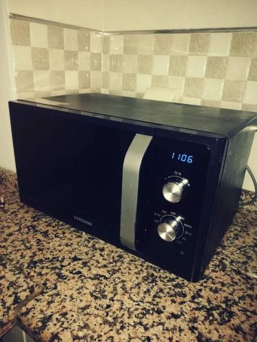 a microwave sitting on a counter in a kitchen at Dar Dhiafa Mayar -دار الضيافة ميار in Mahdia