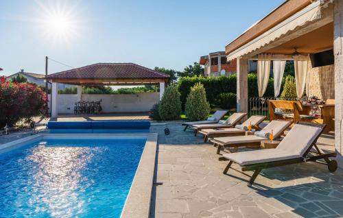 una piscina con tumbonas y un cenador en Stunning Home In Vrsi With Sauna, en Vrsi