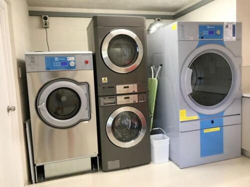 two washing machines and a washer and dryer in a room at Ellerslie Palms Motel in Auckland
