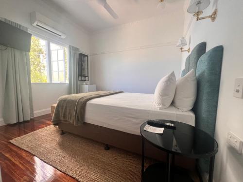 a bedroom with a bed and a table in it at Floriana Boutique Hotel in Cairns