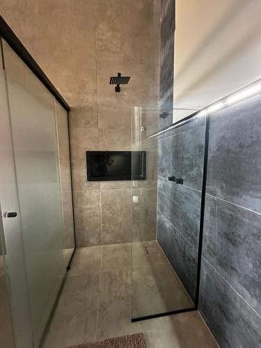 a shower with a glass door in a bathroom at Vinícola Mirantus in Espirito Santo Do Pinhal