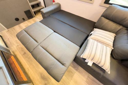 een bruine leren bank in de woonkamer bij Clemson RV Park at the Grove in Pendleton