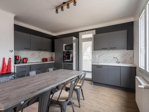une cuisine avec une grande table et des chaises en bois dans l'établissement Maison rénovée pour 8 pers avec terrasse près des plages et activités - FR-1-50-141, à Mimizan