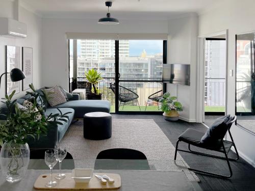 a living room with a couch and a table at Stylish Executive City Pad w Parking and Pool in Perth