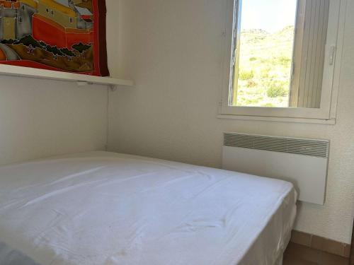 une chambre avec un lit blanc et une fenêtre dans l'établissement Appart 2P/Cabine, 4 Couchages, Plage, Parking, Animaux admis - FR-1-225C-149, à Cerbère