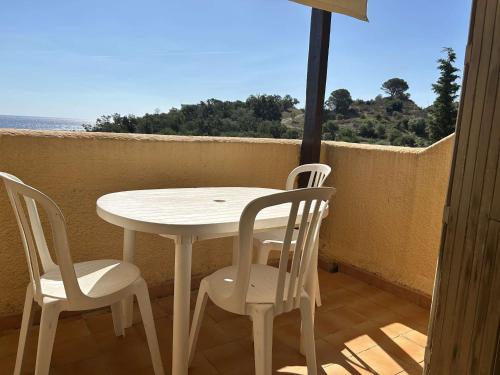 une table blanche et des chaises sur un balcon avec l'océan dans l'établissement Appart 2P/Cabine, 4 Couchages, Plage, Parking, Animaux admis - FR-1-225C-149, à Cerbère