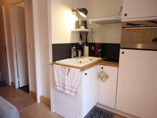 une petite cuisine avec un évier et une cuisinière dans l'établissement Centre-ville Bagnères-de-Luchon T2 avec balcon, WiFi, animaux admis - FR-1-313-233, à Luchon