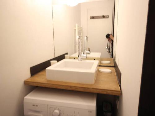 une salle de bain avec un lavabo blanc et un miroir dans l'établissement Centre-ville Bagnères-de-Luchon T2 avec balcon, WiFi, animaux admis - FR-1-313-233, à Luchon