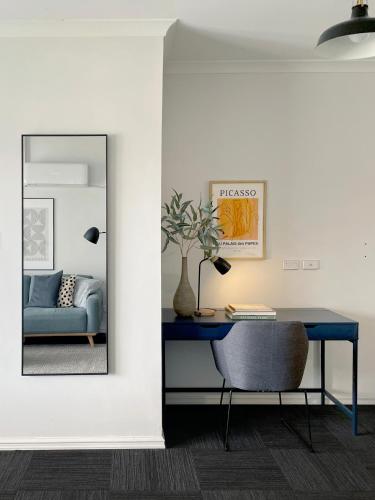 a room with a blue table and a blue chair at Stylish Executive City Pad w Parking and Pool in Perth
