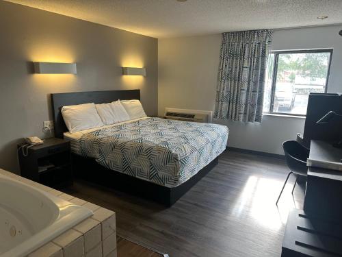a bedroom with a bed and a bath tub at Motel 6-Wisconsin Rapids, WI in Wisconsin Rapids