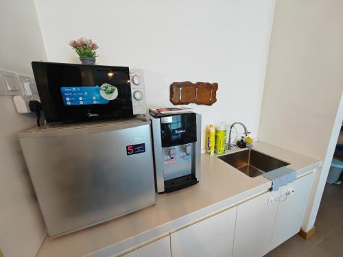 a kitchen with a refrigerator and a tv on top of it at Kuantan City 188 in Kuantan