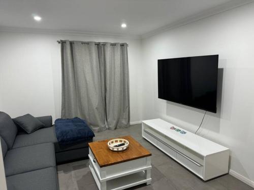 un soggiorno con divano e TV a schermo piatto di Golfers dream 300m to the beach a Dawesville