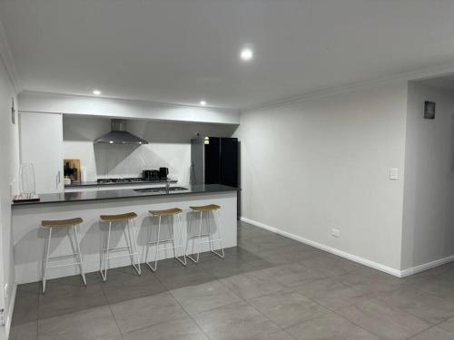 una cucina con bancone e sgabelli di Golfers dream 300m to the beach a Dawesville