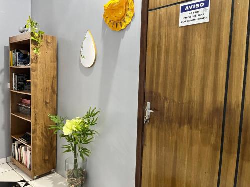 a wooden door in a room with a plant at Ap. 2 quartos próx. Aeroporto in Marabá